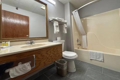 a bathroom with a sink and a toilet and a tub at Super 8 by Wyndham Chenoa in Chenoa