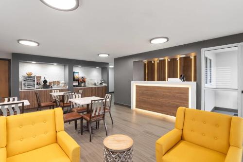 a restaurant with yellow chairs and tables and a bar at Super 8 by Wyndham Chattanooga East - Hamilton Place in Chattanooga