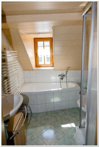 a small bathroom with a tub and a sink at Pension Teichschänke in Zwönitz
