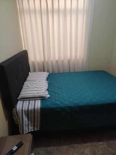a bed sitting in a room with a window at Acogedora habitación in Trujillo
