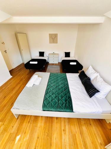 a large white bed in a room with wooden floors at High standard in Campo de Ourique, close to attractions in Lisbon