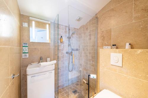 ein Badezimmer mit Dusche, Toilette und Waschbecken in der Unterkunft Hôtel Les Calanques in Les Issambres