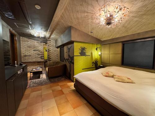 a bedroom with a bed and a couch and a television at ライオンズロック in Nerima