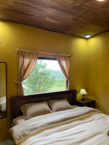a bedroom with a large bed with a window at LoLo Hideaeay in Dồng Văn