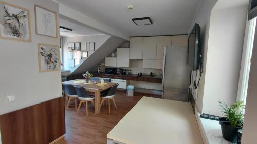 a kitchen and dining room with a table and a refrigerator at Blues Hostel in Konin