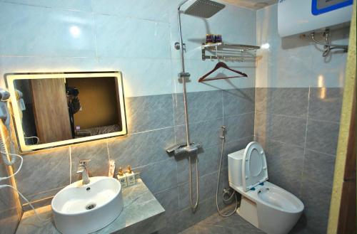 a bathroom with a sink and a toilet and a mirror at LoLo Hideaeay in Dồng Văn