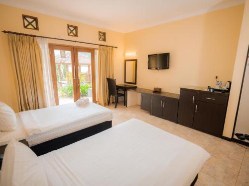a hotel room with two beds and a desk at Grand Pujon View in Songgoriti