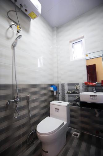 a bathroom with a toilet and a sink at HUNA's HOUSE in Da Thanh