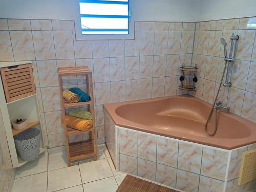 a bathroom with a tub and a shower and towels at Villa Dijoux D'O in Entre-Deux