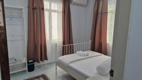 a small bedroom with a bed and a window at Ilham Penarek Pantai Penarik in Pulau Che Selamah