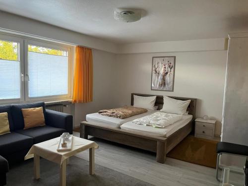 a small bedroom with a bed and a couch at Haus Panorama Sankt Andreasberg in Sankt Andreasberg