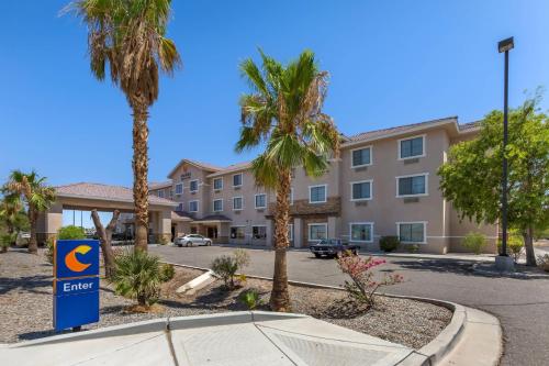 a hotel sign in front of a building with palm trees at Comfort Inn and Suites Yuma I-8 in Yuma