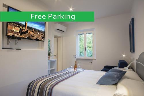 une chambre avec un lit et une télévision à écran plat dans l'établissement La Coroncina Lodging, à Sienne