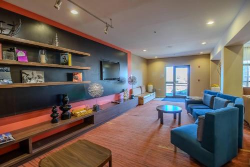 a living room with a blue couch and a table at Country Inn & Suites by Radisson, Convention Center in Altoona