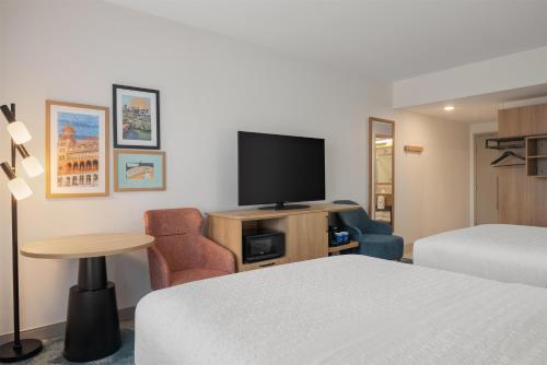 a hotel room with a bed and a flat screen tv at Hampton Inn By Hilton Richmond Chester, VA in Chester