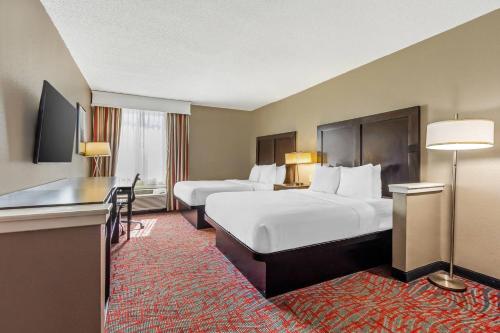 a hotel room with two beds and a desk at Comfort Inn & Suites North Charleston - Northwoods in Charleston Heights