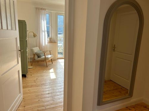 a hallway with a mirror and a room with a chair at Residenz Moselliebe Traben in Traben-Trarbach