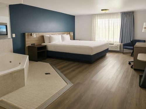 a hotel room with a bed and a bathroom at Rancho San Diego Inn & Suites in El Cajon