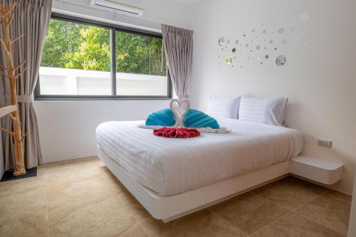 a bedroom with a white bed with a large window at villa carissa 9 in Nathon Bay