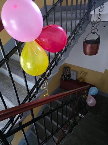 a group of balloons hanging from a stair railing at ROOMS CA' TUNIN- ideale per il Trenino Rosso- a pochi minuti a piedi dalla stazione in Tirano