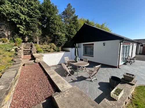 a patio with a table and chairs and a building at Sharpley Hall Garden Studio not far from Seaham Beach offering Quiet Private Stay with Secure Parking in Seaham