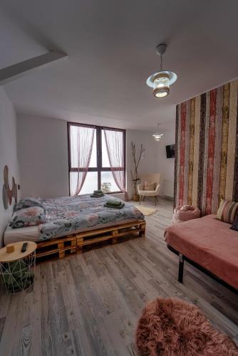 a bedroom with a large bed and a couch at Cabana La Cassian in Vulcan