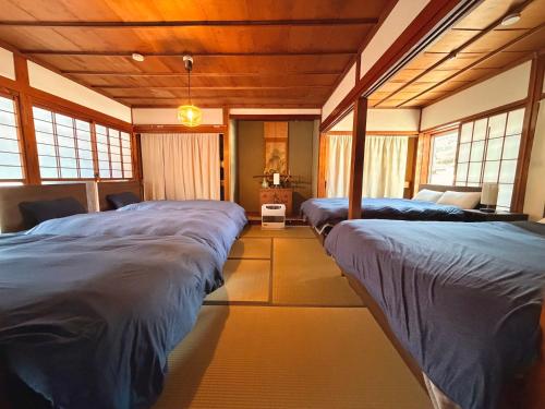 a room with three beds in a room with windows at HAYU Hearth Yuzawa in Yuzawa