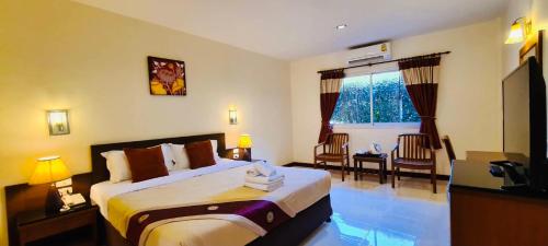 una habitación de hotel con una cama y una ventana en Prachuap Place Hotel, en Prachuap Khiri Khan
