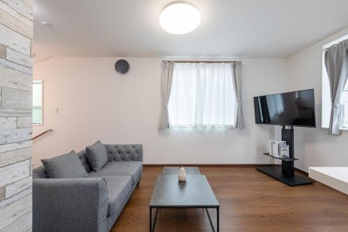 a living room with a couch and a tv at Villa Taito in Tokyo