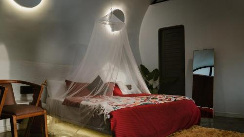a bedroom with a bed with a mosquito net on it at Earth's Embrace in Kalpetta