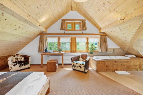 a bedroom with a bed and a tub in a room at Bären - Das Gästehaus in Gais