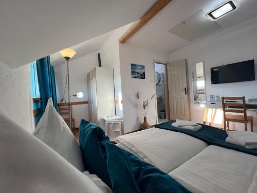 a bedroom with two beds and a tv in it at Pensiunea Andra in Jurilovca