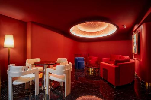 a room with red walls and white chairs and a table at KiN Hotel Onsen in Ho Chi Minh City