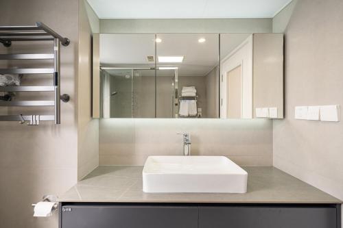a bathroom with a white sink and a mirror at Today-Lujiazui Riverside,Bund Riverview in Shanghai