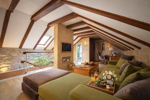 a living room with a green couch and a table at Conte Hotel & Restaurant in Perast