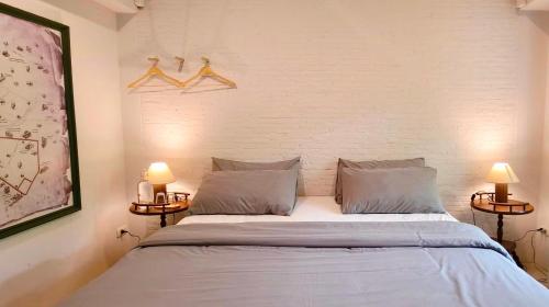 a bedroom with a large white bed with two lamps at Ena Boutique Hotel & Cafe in Chiang Mai