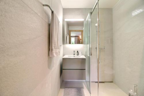 a bathroom with a glass shower and a sink at Garden Heart of the village Swedish Stove in Champéry