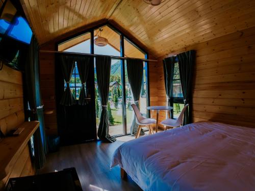 a bedroom with a bed and a table and chairs at Roben Village in Suseni
