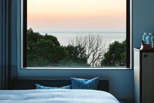 a bedroom with a large window with a view of the ocean at Fairfield by Marriott Mie Kumano Kodo Mihama in Mihama