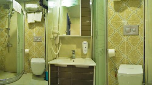 a bathroom with a sink and a toilet at Taşucu Kaptan Suit Otel in Silifke