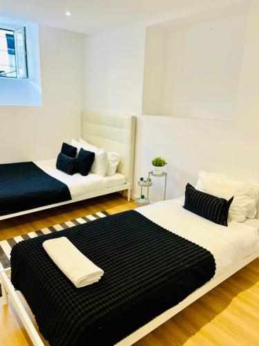 two beds in a room with black and white at High standard in Campo de Ourique, close to attractions in Lisbon
