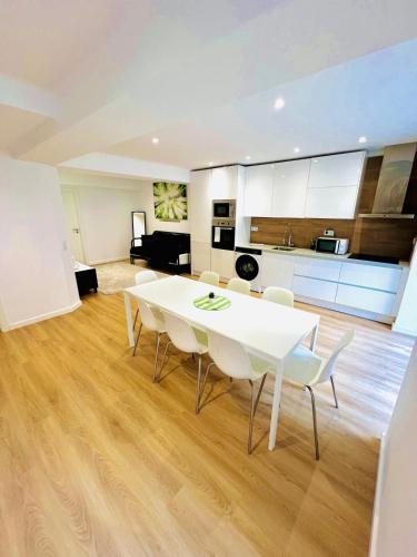 a kitchen and living room with a white table and chairs at High standard in Campo de Ourique, close to attractions in Lisbon