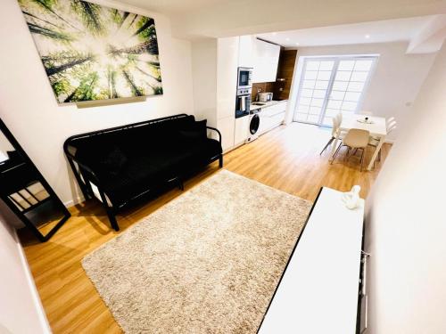 a living room with a black couch and a table at High standard in Campo de Ourique, close to attractions in Lisbon