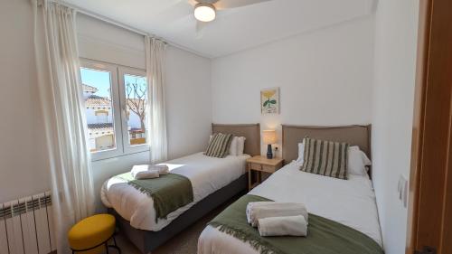 a bedroom with two beds and a window at Villa with private pool and BBQ on Mar Menor Golf Resort in Torre-Pacheco