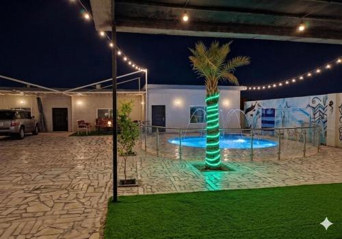 a palm tree in the middle of a room with lights at شالية نخلة in Buraydah