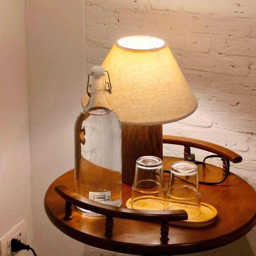 a lamp and two glasses and a bottle on a table at Ena Boutique Hotel & Cafe in Chiang Mai