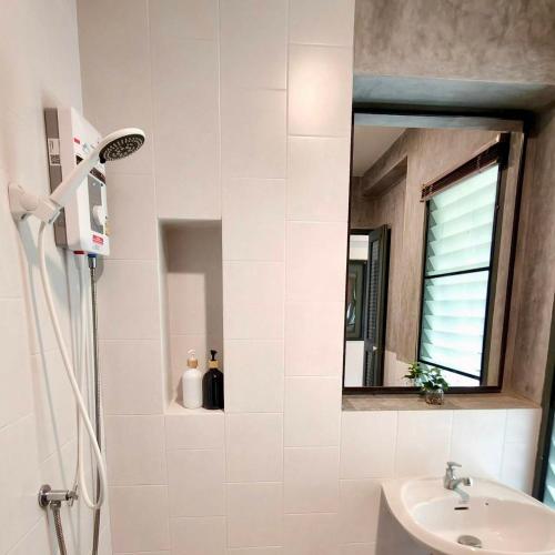 a bathroom with a shower and a sink and a mirror at Ena Boutique Hotel & Cafe in Chiang Mai