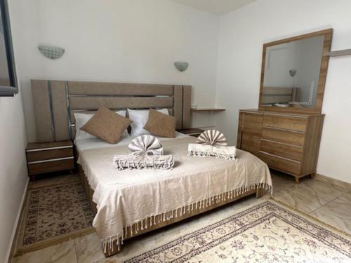a bedroom with a large bed with a large mirror at Villa Al-Qamar in Midoun