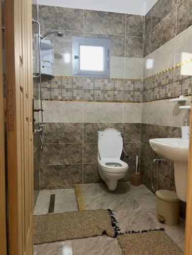 a bathroom with a toilet and a sink at Villa Al-Qamar in Midoun