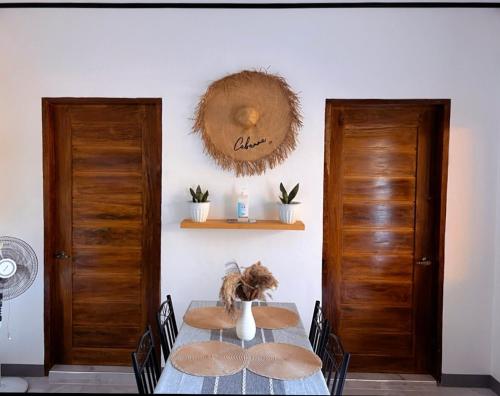 a dining room with a table and two wooden doors at Liminaya Villa in El Nido
